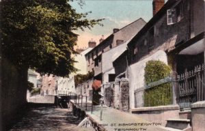 Hand coloured postcard of Fore Street, Bishopsteignton showing Myrtle Cottage and Blacksmiths