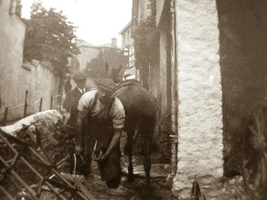 Sepia Photograph Gordon Major outside Fore Street Smithy