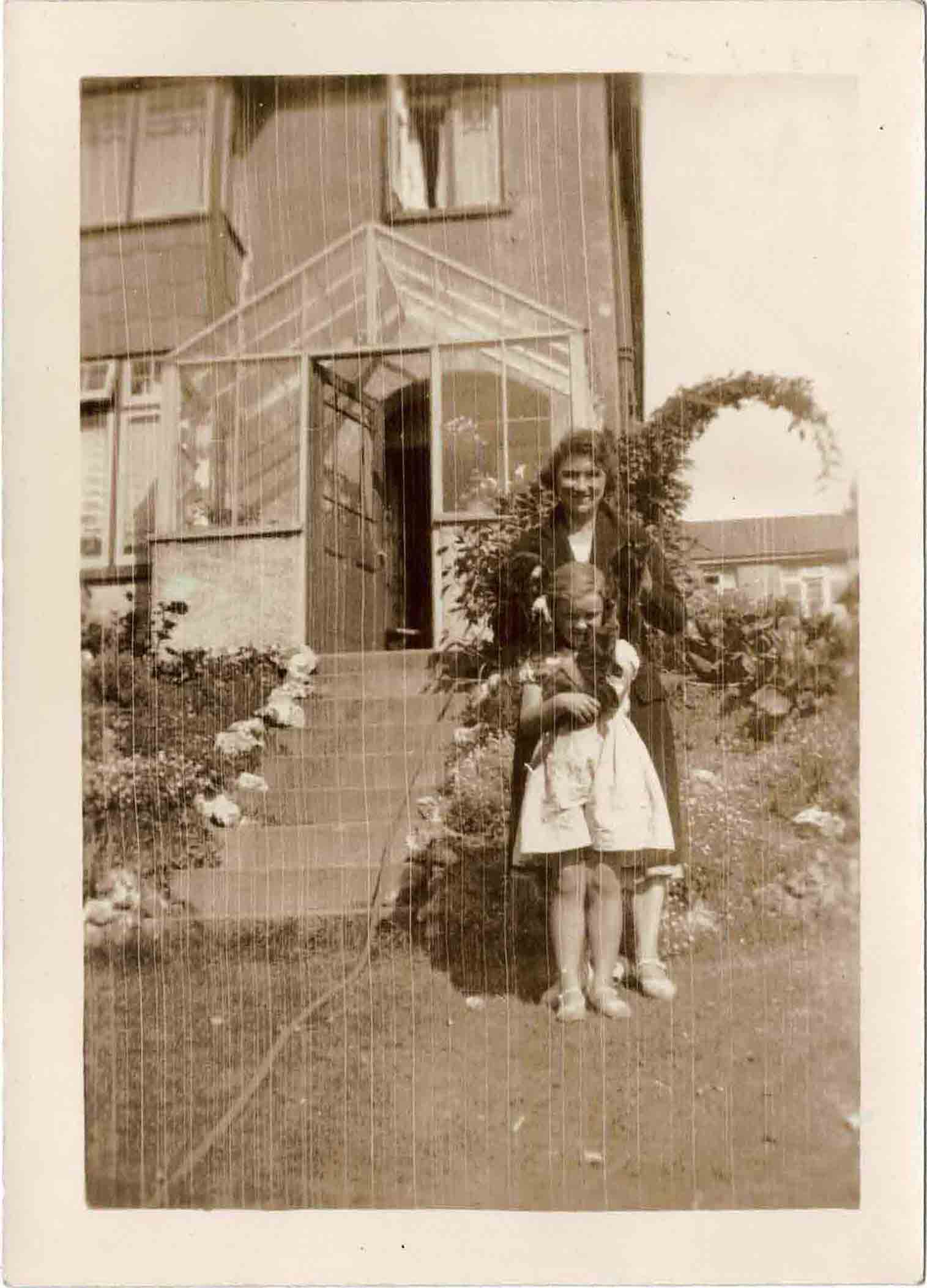 Photograph of Grace Coombe née Loud and Molly Coombe outdoors with cats.