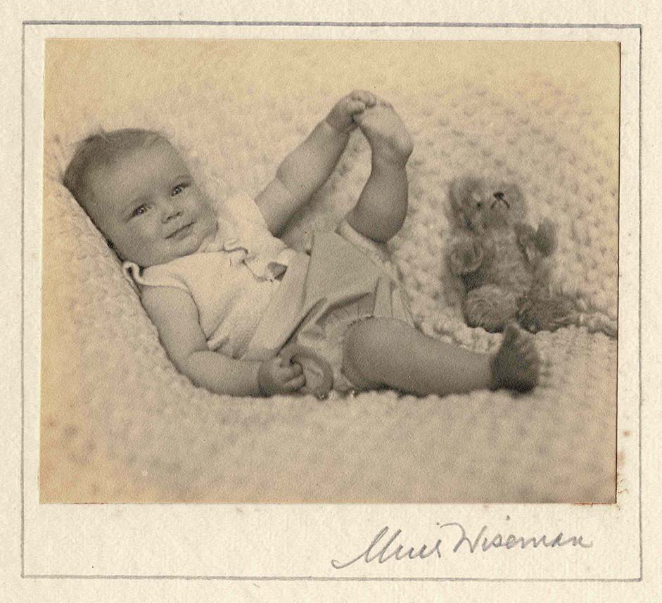 Photograph of an infant Molly Coombe with a toy bear, 1930.