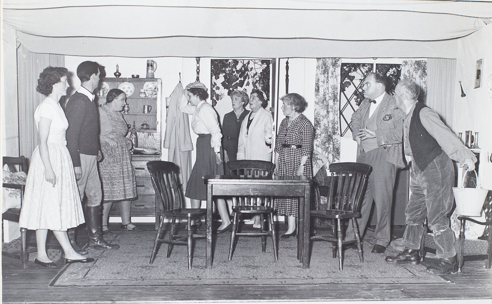 Photograph of the actors in a scene from the 1960s play 'The Camel's Back' performed by the Bishopsteignton Players