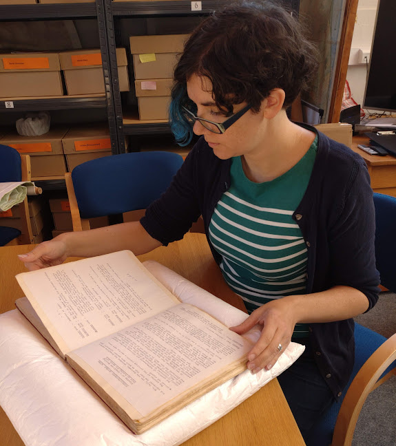 BH volunteer using a book pillow to carefully open a book